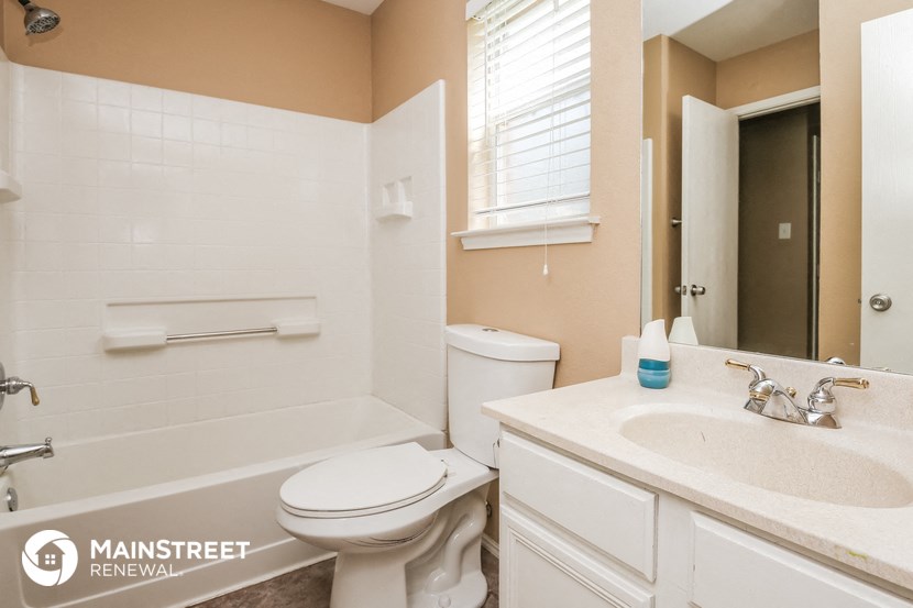 a bathroom with a toilet sink and tub and a mirror