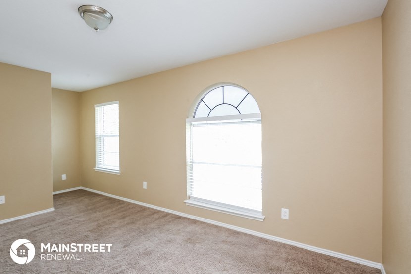 the spacious living room with a large arched window