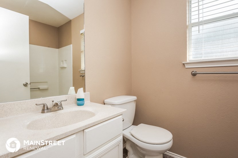 a bathroom with a toilet and a sink and a mirror