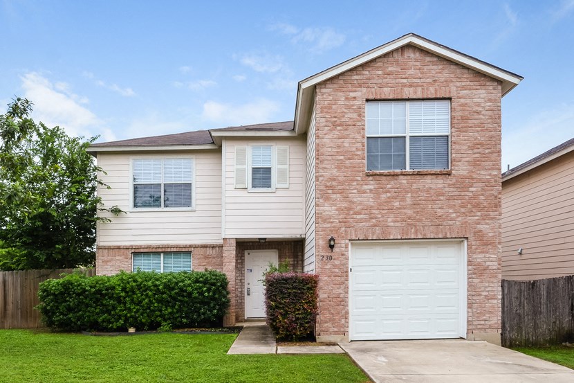 a white and brick house with a white garage door