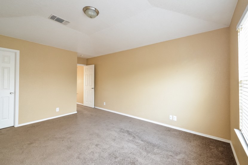 an empty living room with beige walls and carpet