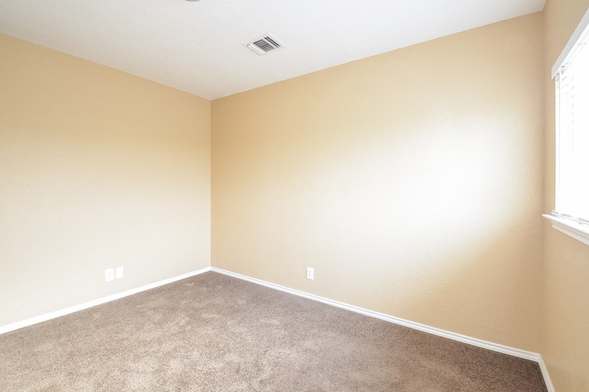 an empty room with carpet and a window
