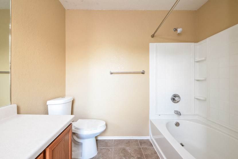 a bathroom with a toilet and a tub and a sink
