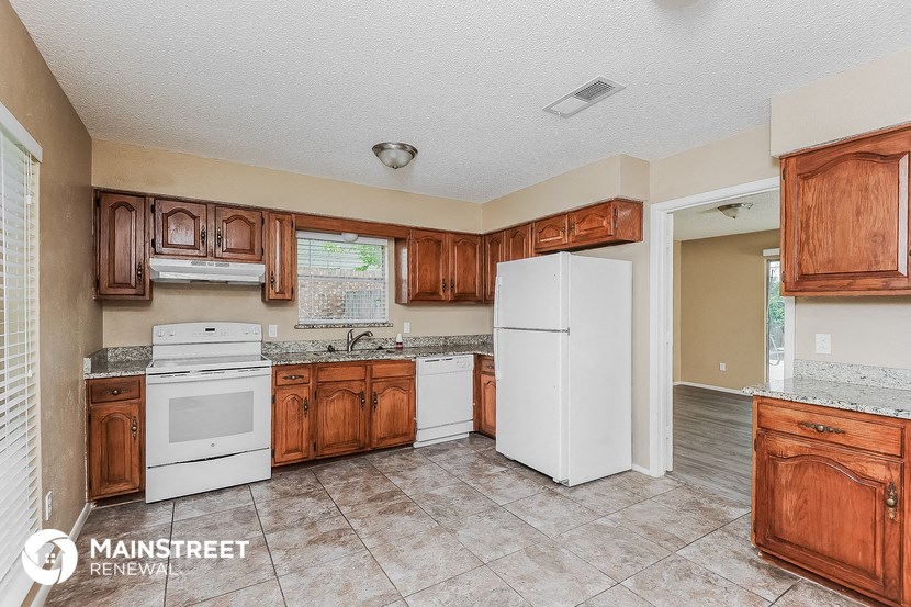 a kitchen with white appliances and wooden cabinets