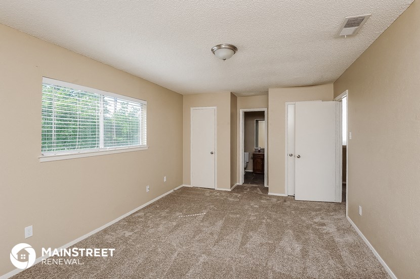 a spacious living room with carpet and a large window
