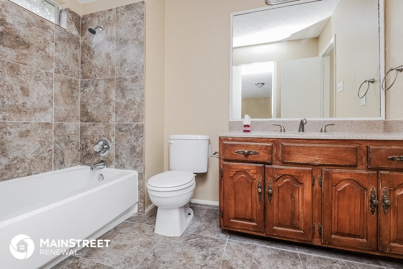 a bathroom with a toilet sink and tub and a mirror