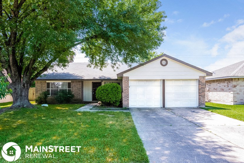 a home with a white garage door and a tree