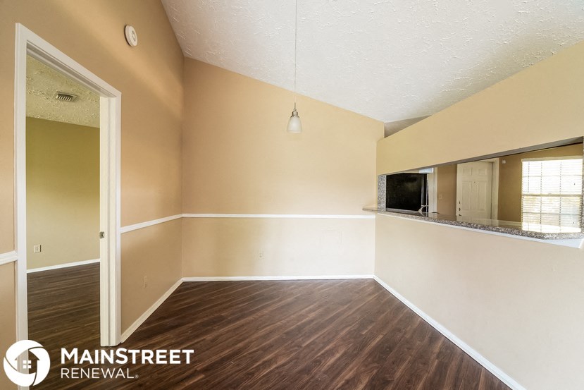 the living room of an empty house with wood floors and a tv