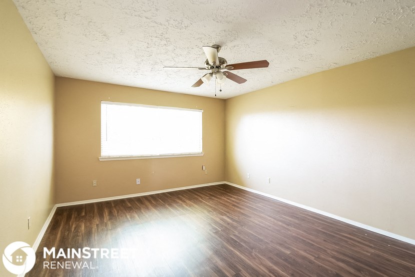 a bedroom with a ceiling fan and wood floors
