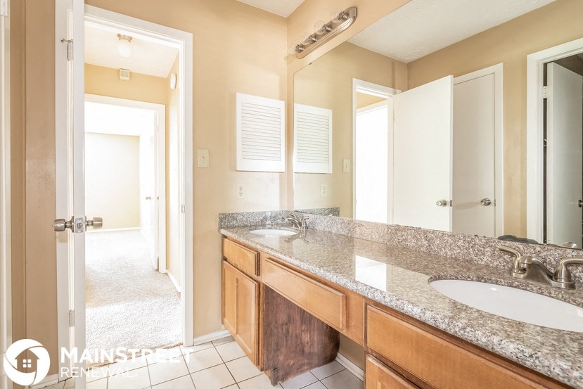a bathroom with two sinks and a large mirror