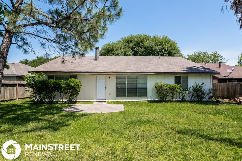 a small white house with a yard and a tree