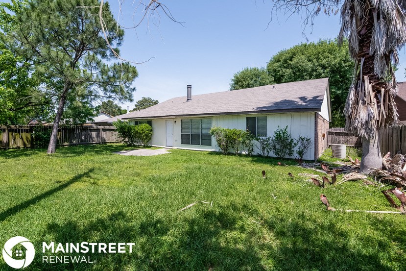 a small white house with a yard and a tree