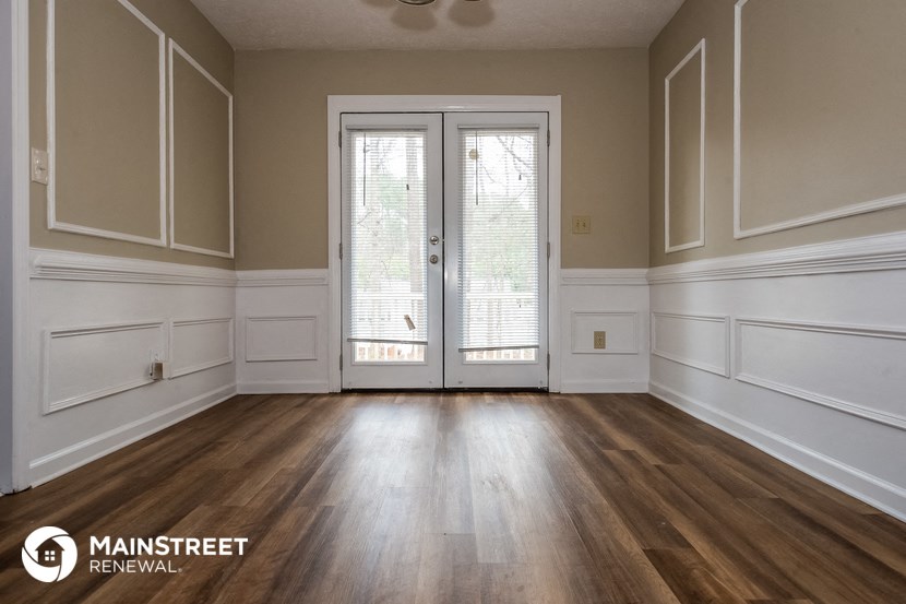 a living room with wood floors and white walls and doors