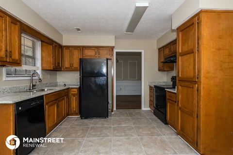 a kitchen with wooden cabinets and a black refrigerator