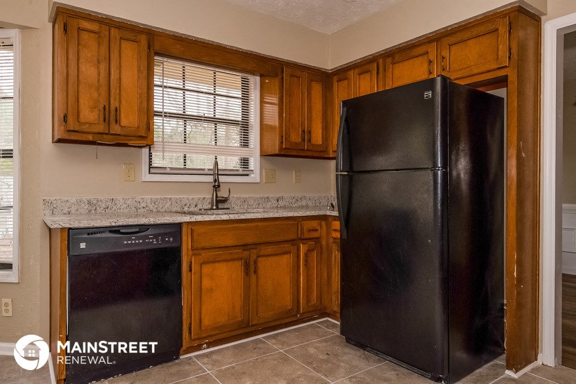 a kitchen with wooden cabinets and a black refrigerator