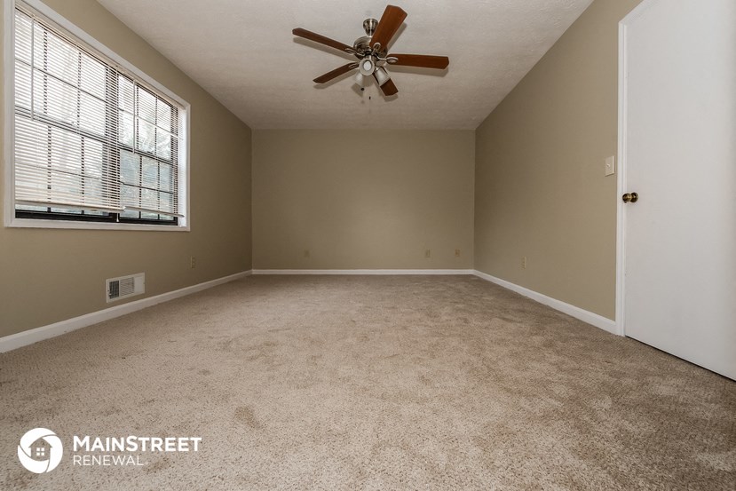 the master bedroom has a carpeted floor and a ceiling fan