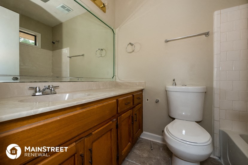 a bathroom with a toilet and a sink and a mirror