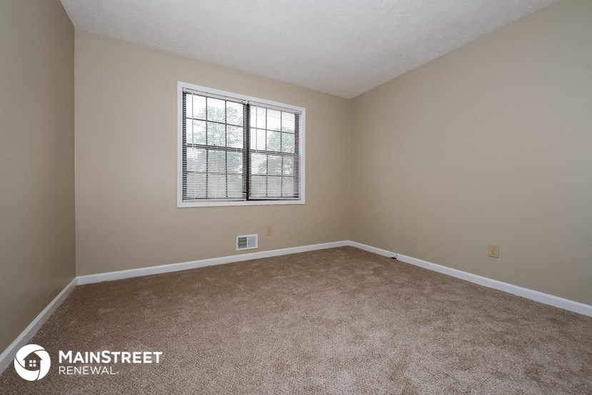 an empty room with carpet and a window