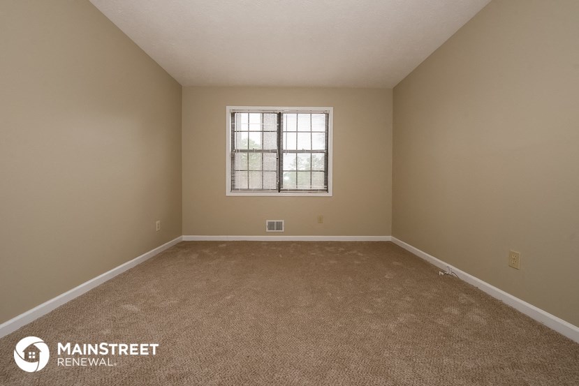a empty room with carpet and a window