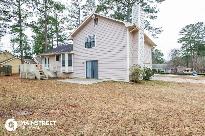 a white house with a yard and a blue door