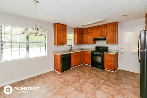 a kitchen with wood cabinets and black appliances and a window