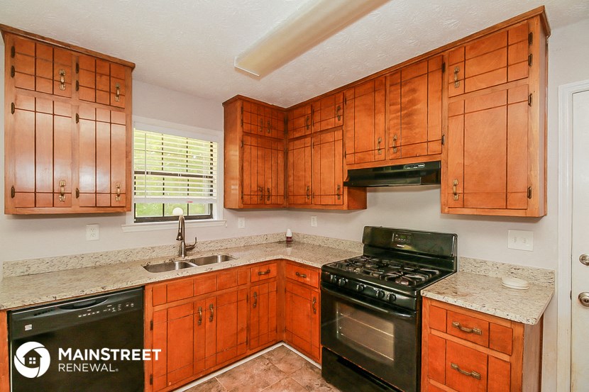 a kitchen with wood cabinets and black appliances and a sink