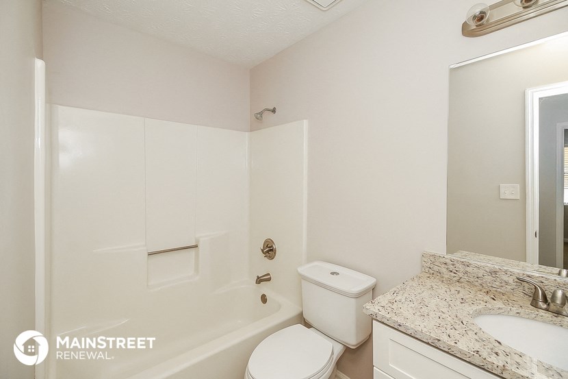 a bathroom with a toilet and a tub and a sink