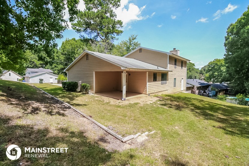 a small tan house with a yard and a garage