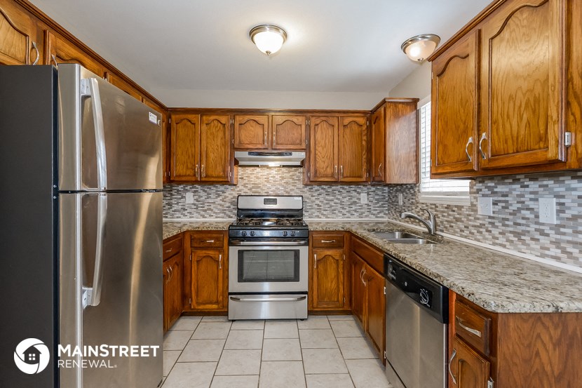 a kitchen with wooden cabinets and stainless steel appliances