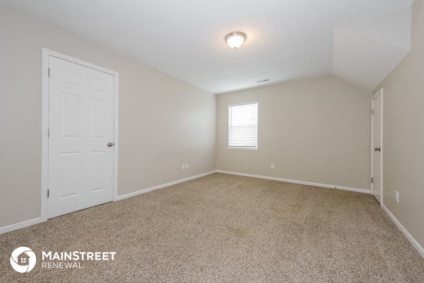 the upstairs bedroom has a carpeted floor and a white door