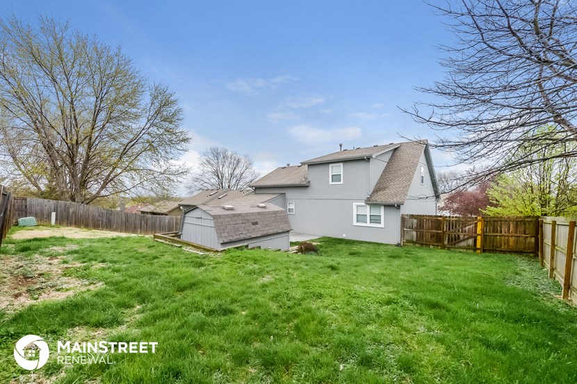 a backyard with a house and a yard and a wooden fence