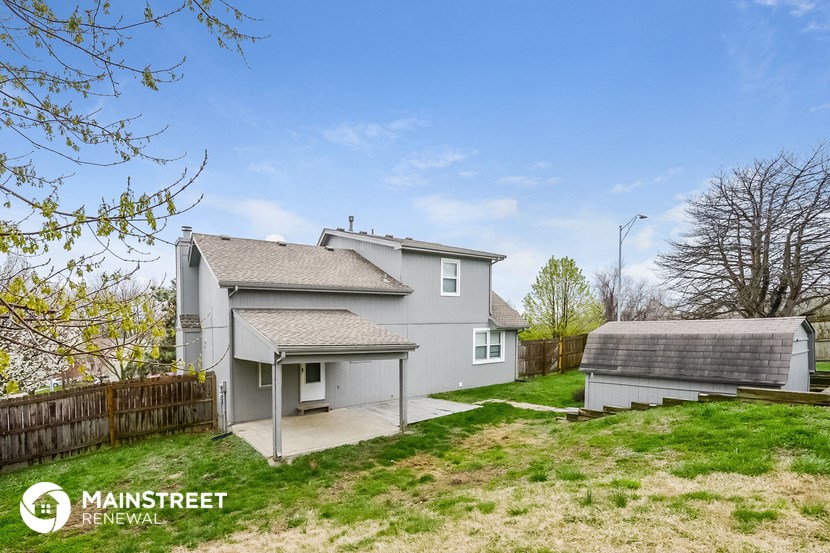 a gray house with a yard and a fence