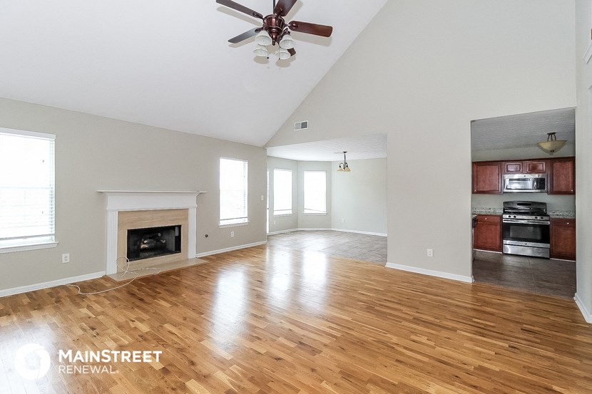 the living room with wood floors and a fireplace