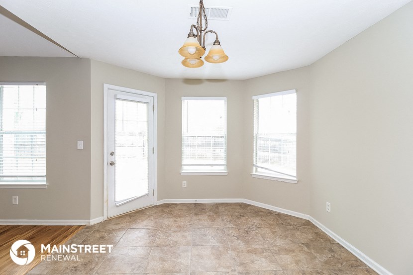 the living room of a home with a large window and a chandelier