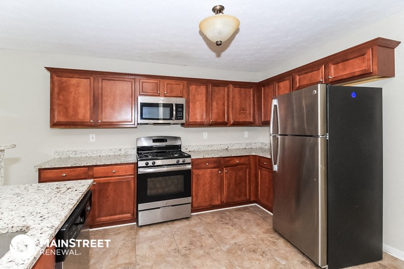 a kitchen with wooden cabinets and stainless steel appliances