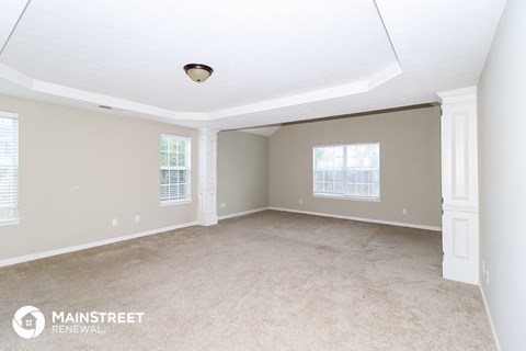 the living room of a home with carpet and a large window