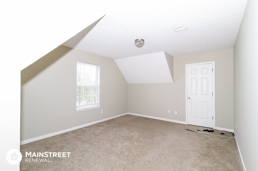 a bedroom with a carpeted floor and a white door