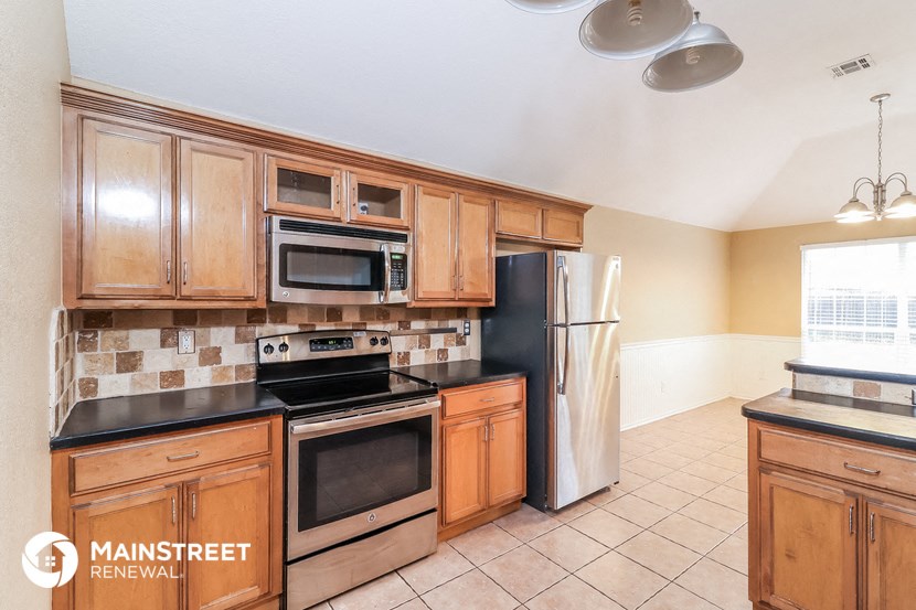 a kitchen with wooden cabinets and stainless steel appliances