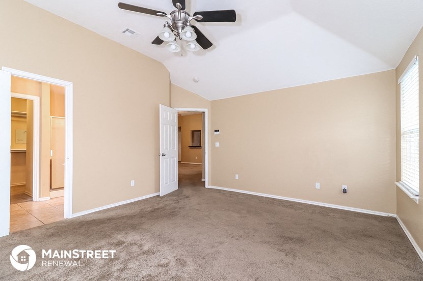 a living room with carpet and a ceiling fan