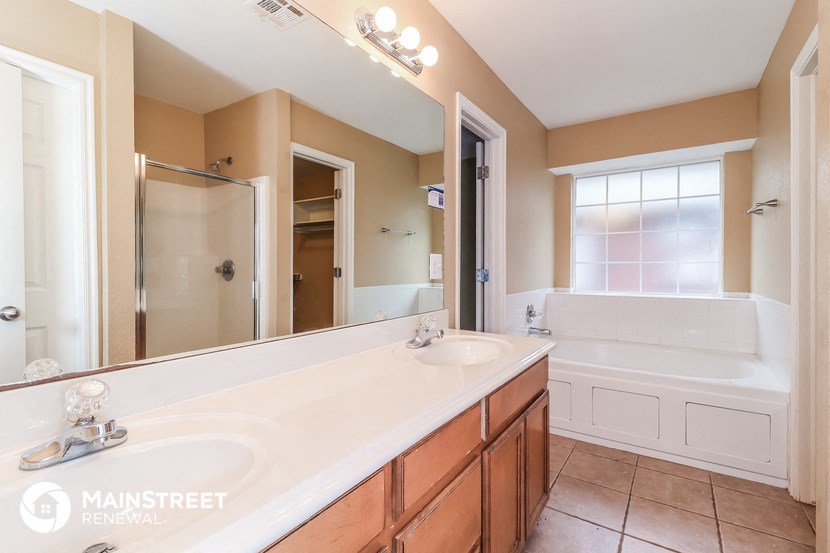 a bathroom with a sink and a tub and a mirror