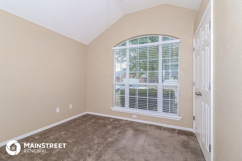 the living room of a home with a large window and carpet