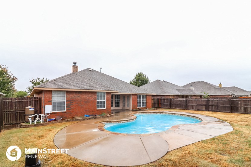 a backyard swimming pool in front of a house