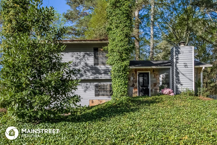 a white house with a tree in front of it