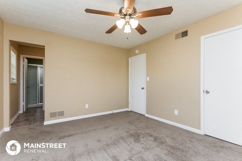 an empty living room with a ceiling fan