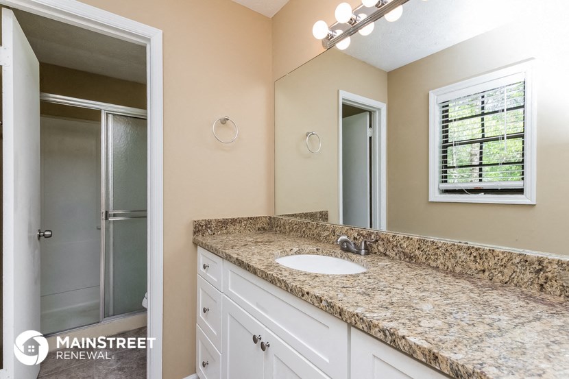 a bathroom with a sink and a shower and a mirror