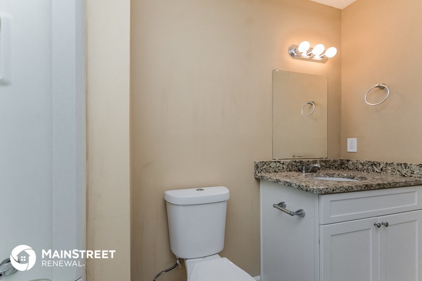 a bathroom with a toilet and a sink and a mirror