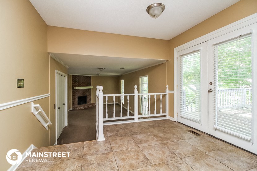 the entryway into a home with large windows and tile flooring