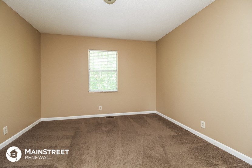 the interior of a room with carpet and a window