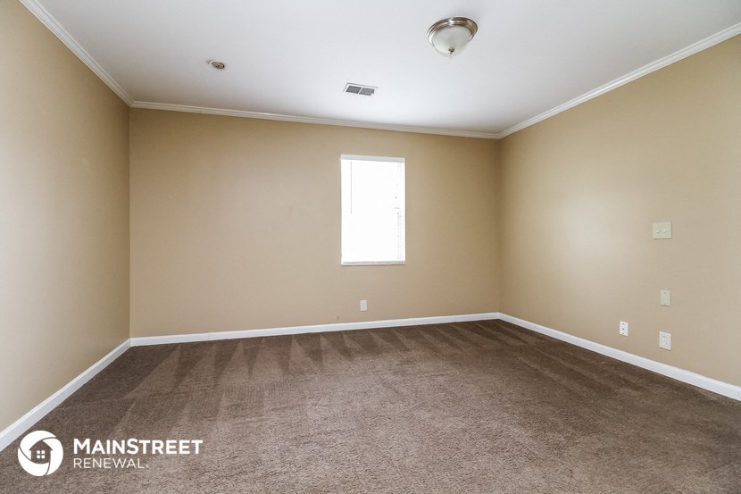 an empty room with carpet and a window
