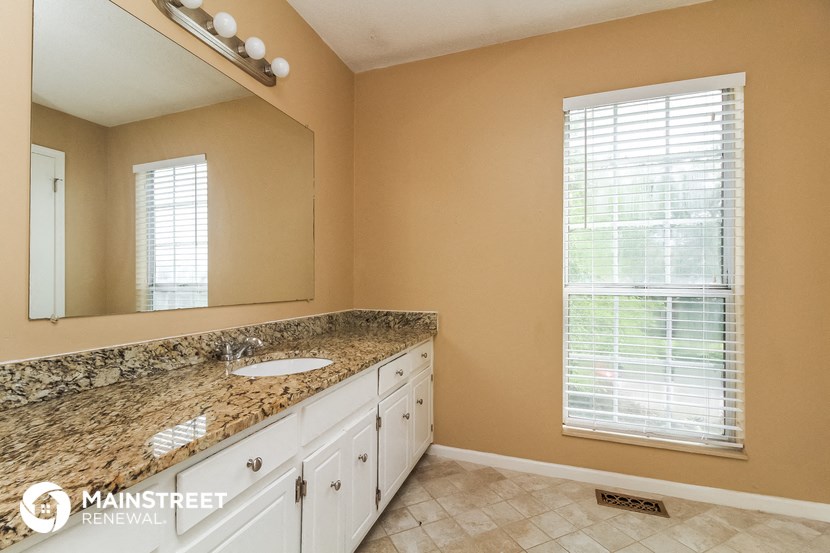 a bathroom with a sink and a mirror and a window